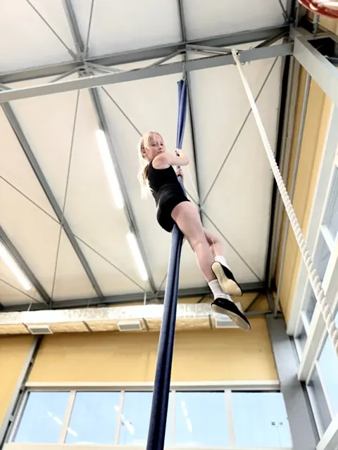 Cwiczenia na podwieszanej szarfie w hali sportowej